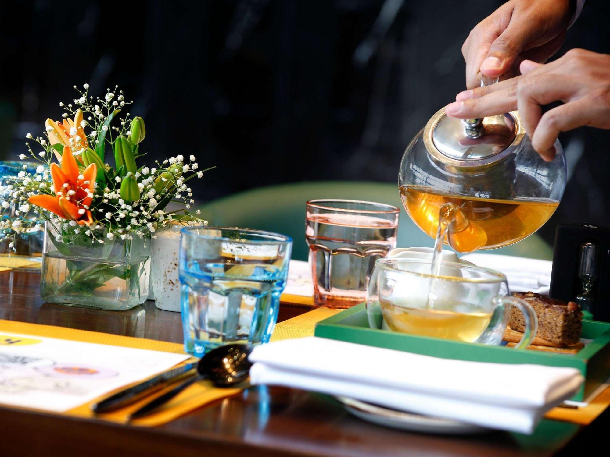 Novotel Kolkata Hotel And Residences Calcutá Exterior foto A server pours tea at a restaurant